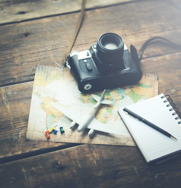 travel accessories: camera, map,airplane with notepad on wood background travel accessories: camera, map,airplane with notepad on wood background